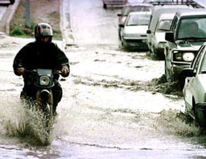 Un motorista atraviesa una calle afectada por la lluvia en Cádiz.
