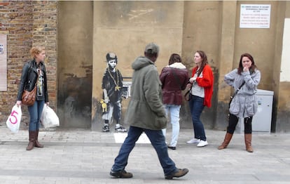 La obra terminada de Bansky ya puede ser admirada por los habitantes de Londres. Finalmente el artista se ha decidido por un niño que lleva un aparato de música y ha utilizado la rejilla de la pared a modo de altavoz.