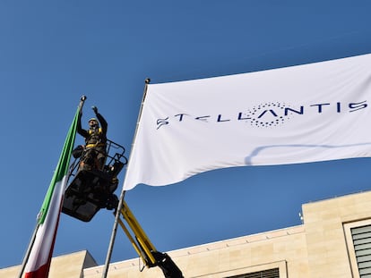 Un operario monta una bandera de Stellantis en una de las fábricas del grupo en Estados Unidos.