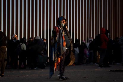 Migrantes venezolanos  que buscan asilo en Estados Unidos se paran cerca de la valla fronteriza de Yuma, Arizona mientras esperan ser procesados por la patrulla fronteriza.