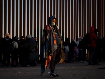 Migrantes venezolanos  que buscan asilo en Estados Unidos se paran cerca de la valla fronteriza de Yuma, Arizona mientras esperan ser procesados por la patrulla fronteriza.