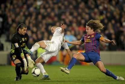 Pinto atrapa la pelota en presencia de Benzema y Puyol.