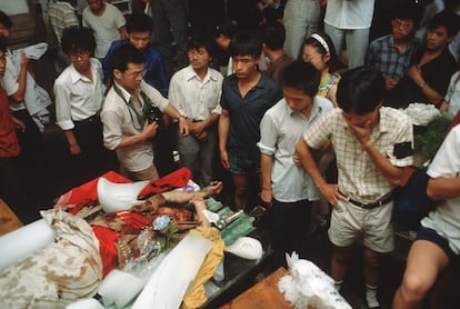 Para las 5.40 del 4 de junio, Tiananmen había sido desalojada, y el sueño de reformas y democracia de toda una generación de chinos se evaporó. En la foto, varias personas observan el cadaver de un manifestante, masacrado por el ejercito chino durante la represión en la Plaza de Tianamen, el 4 de junio de 1989.