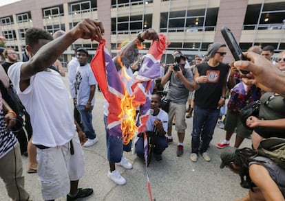 Miembros de los Panteras Negras queman una bandera confederada durante su manifestación.