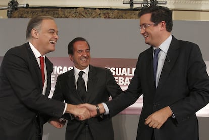 Esteban González Pons (izquierda) saluda a Óscar López en presencia de José Miguel Contreras (presidente de UTECA), durante la jornada de políticas audiovisuales celebrada ayer en Madrid.