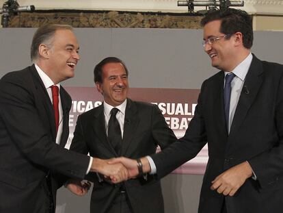 Esteban González Pons (izquierda) saluda a Óscar López en presencia de José Miguel Contreras (presidente de UTECA), durante la jornada de políticas audiovisuales celebrada ayer en Madrid.