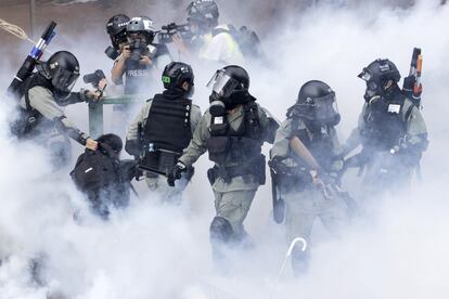 Agentes de policía se mueven a través de una nube de humo mientras detienen a los manifestantes. El Ejército chino, que cuenta con miles de soldados en Hong Kong desde 1997, cuando China recuperó el control del territorio, está decidido a "salvaguardar los intereses de la soberanía" china, ha subrayado un portavoz gubernamental.