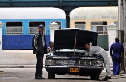 Un hombre repara un coche de fabricación americana.