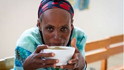 Una mujer sostiene un tazón de puré en un centro de alimentación terapéutica para niños y madres con malnutrición de Etiopía.