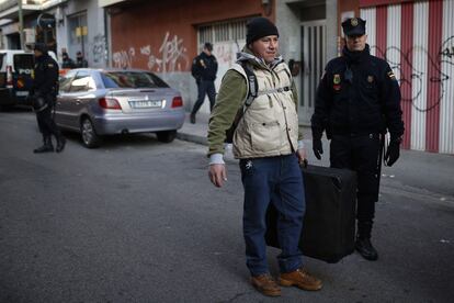 Un miembro de la polic&iacute;a nacional vigila al ciudadano de origen colombiano John Jairo Nanez Betancur tras haber sido desalojado de su casa hoy en Madrid.