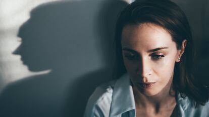 El rostro de una mujer mirando al frente y su sombra.