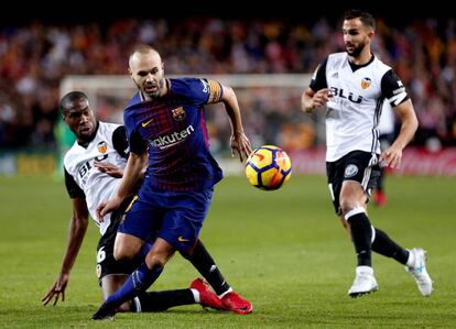 El centrocampista francés del Valencia Geoffrey Kondogbia disputa el balón ante el jugador del Barcelona Andrés Iniesta.