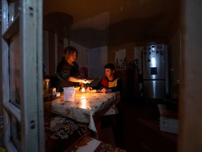 Una mujer y su hijo cenan en su casa de Stepanakert a la luz de una vela tras los cortes de electricidad por el bloqueo de Azerbaiyán al enclave armenio de Nagorno Karabaj, el pasado 18 de enero.