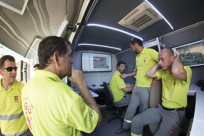 Miembros del Grupo de Emergencias de Andalucía (GREA), en el interior del vehículo donde analizan la situación.