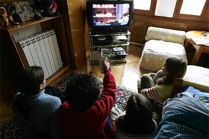 Un grupo de niños observa las emisiones de televisión.