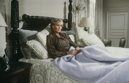 Krystle Carrington en su cama, una pieza escultórica de madera maciza con patas torneadas a la altura de los dioses que levitan en ella. |