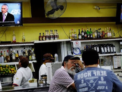 Trabalhadores assistem em um bar a um pronunciamento de Michel Temer da TV.