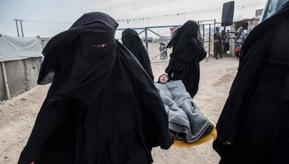 A sick girl is taken to a field hospital in the Al Hol camp in Syria.