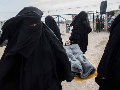 A sick girl is taken to a field hospital in the Al Hol camp in Syria.