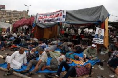 Seguidores del depuesto presidente egipcio Mohamed Mursi descansan durante una manifestación a las afueras de la mezquita Rabaa al-Adawiya en El Cairgo (Egipto) hoy, martes 23 de julio de 2013.