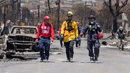 Miembros de un equipo de rescate caminan por una de las calles afectadas, este sábado.