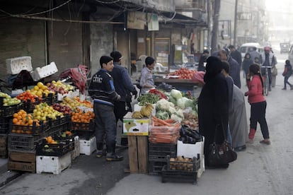 Vista de una frutería del barrio de al-Shaar, donde la gente acude a comprar, en la ciudad de Alepo (Siria).