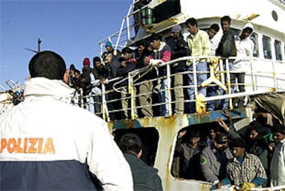 Un policia italiano vigila un barco con más de 400 inmigrantes ilegales en el puerto de Catania.