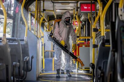 Personal militar desinfecta un autobús en la terminal de Santa Candida para conbatir la propagación del virus, en Curitiba, estado de Parana (Brasil).