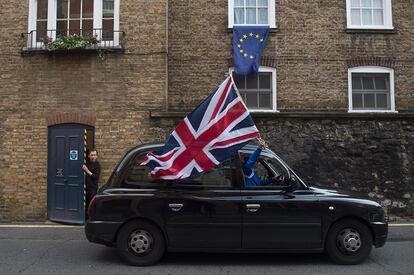 Un taxista londinense ondea una bandera británica por las calles de Londres, tras conocerse los resultados del 'Brexit'.