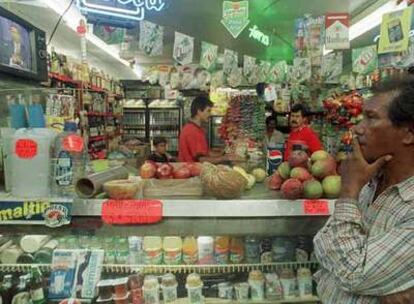 Un hombre atiende a un discurso en televisión de Hugo Chávez en un supermercado de Caracas.