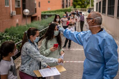 A health worker performs temperature checks in the Madrid district of Vallecas.