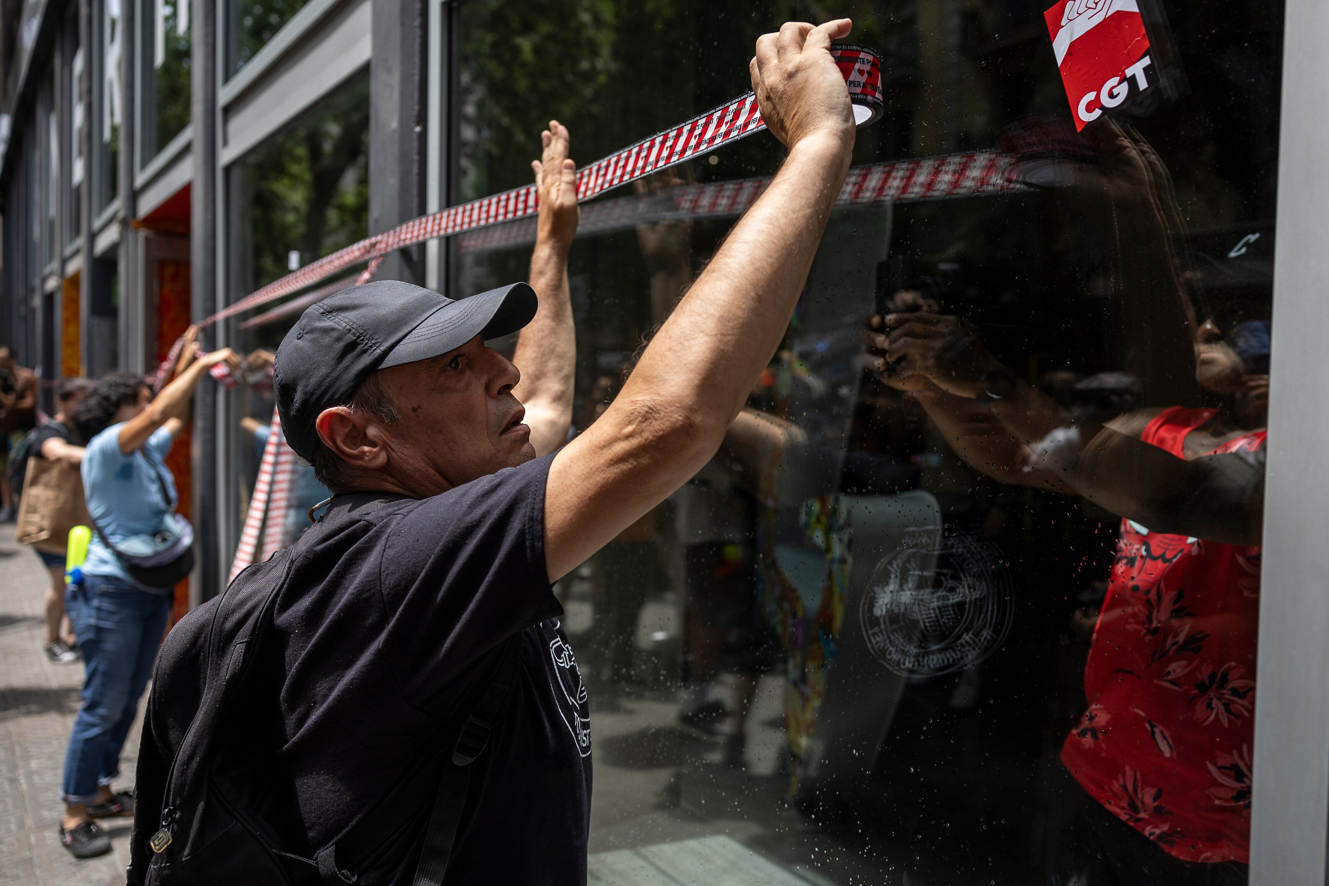 Un manifestante precinta simbólicamente un establecimiento hotelero.