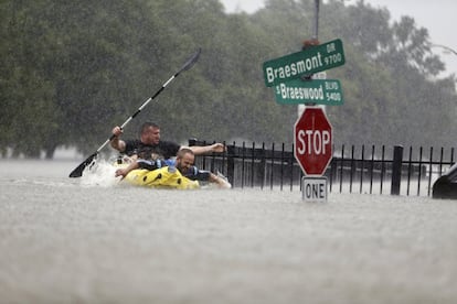 Dois homens tentam vencer a corrente em uma lancha em Brays Bayou, Houston.