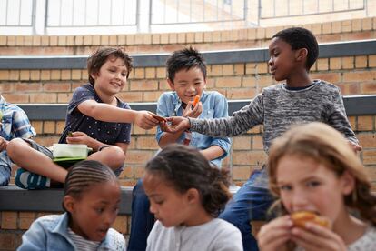 Varios niños en un colegio comparten el almuerzo.