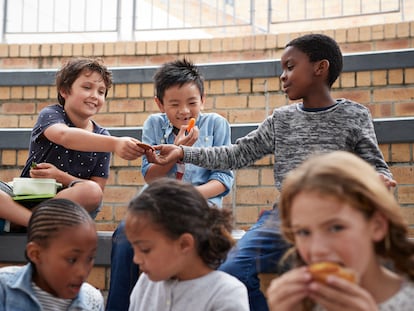 Varios niños en un colegio comparten el almuerzo.