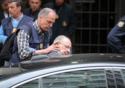 Un agente introduce a Rodrigo Rato en un coche tras su detención, el 16 de abril de 2015.