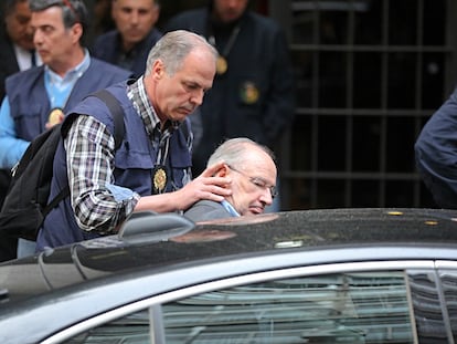 Un agente introduce a Rodrigo Rato en un coche tras su detención, el 16 de abril de 2015.