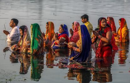 Um grupo de indianos dá graças a Suria, deus do Sol, nas águas do rio Sabarmat, em Ahmedabad (Índia).