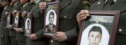 Police officers in Colombia hold photographs of their fellow officers who were kidapped by the FARC.