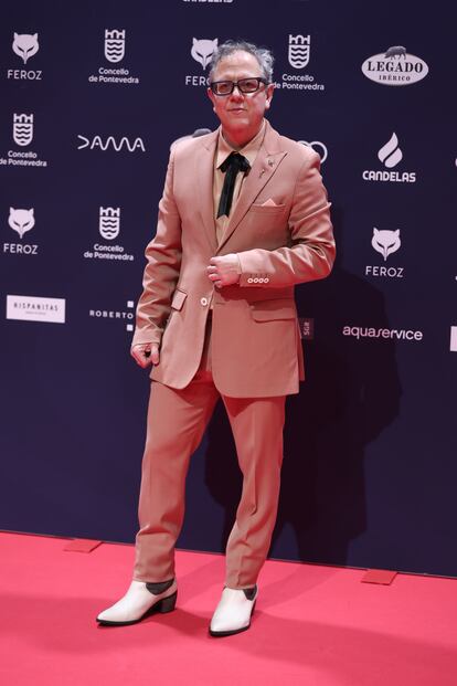 El actor Óscar de la Fuente, nominado a mejor actor de reparto de una película por 'La casa', con traje en color salmón y botines blancos.