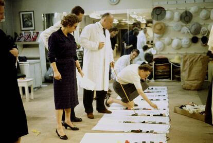 El dise&ntilde;ador Christian Dior (con bata), en los talleres de su firma en Par&iacute;s en 1957.