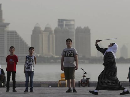 Una mujer juega con unos niños con una raqueta de bádminton el pasado mayo en Doha.