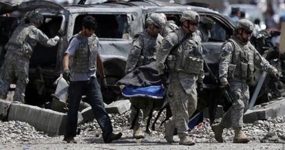 Soldados estadounidenses portan una camilla con el cuerpo de una de las víctimas del atentado perpretado contra un convoy de la OTAN