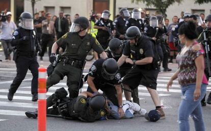 Agentes antidisturbios detienen a un manifestante en una protesta por la muerte de los dos j&oacute;venes en Anaheim, California.