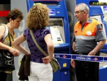 Un vigilante de seguridad de la estación de Nuevos Ministerios impide el paso a dos pasajeras en la segunda jornada de huelga en el Metro de la capital, cuyo servicio está completamente interrumpido al haberse incumplido los servicios mínimos.