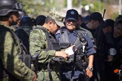 Members of the Mexican army disarm municipal police officers in Apatzingán.