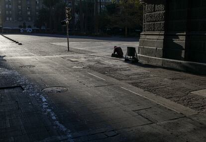 Una persona sin hogar en la Plaza de Armas, vacía de peatones durante el último confinamiento decretado en Santiago, Chile, este marzo.  