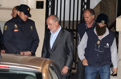 Rodrígo Rato, sale de su despacho en Madrid, acompañado de policías y miembros de la Agencia Tributaria, después de que lo registraran.
