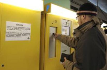 Un joven deposita una moneda en un cajero del aparcamiento de la T4 en el aeropuerto de Madrid-Barajas. EFE/Archivo
