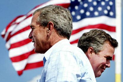 Bush (en primer plano) y su hermano Jeb, gobernador de Florida, tras un mitin celebrado ayer en ese Estado.